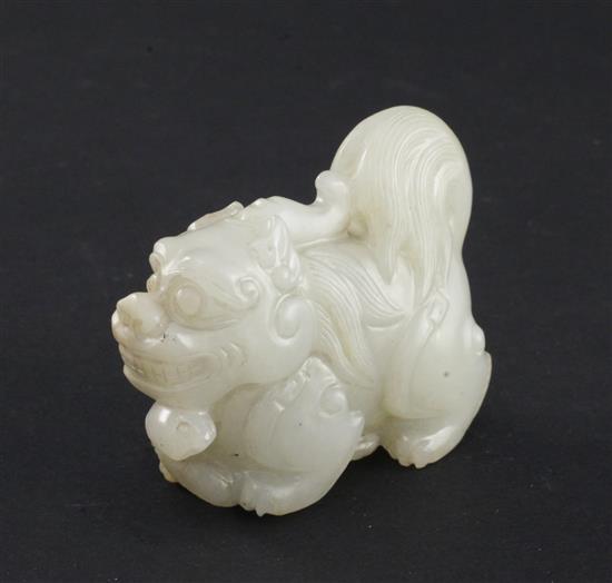 A Chinese pale celadon jade group of a lion-dog and a snake, 6.3cm